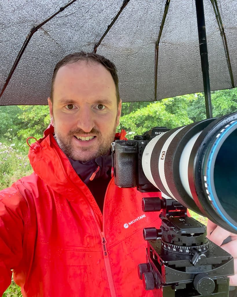 tim-smalley-tall A photograph of woodland photographer Tim Smalley out in the woods on a rainy day.